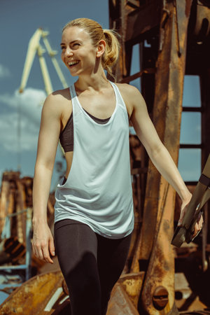 Blonde fitness woman training with trx fitness straps. Young attractive woman posing with trx...