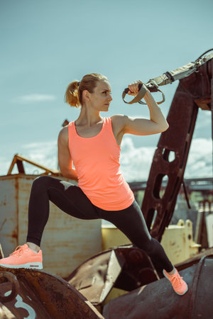 Muscular female athlete exercising push up outside in sunny day. Fit shirtless woman fitness model...