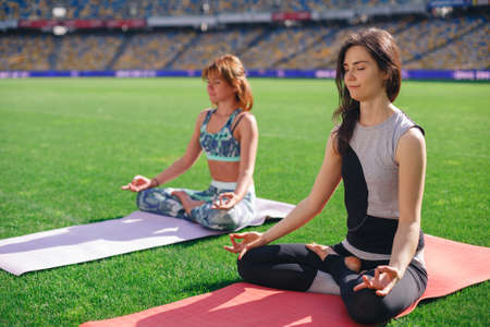 Yoga at the stadium, outdoor with effect light, health woman, Yoga woman and concept of healthy lifestyle and relaxation.の写真素材