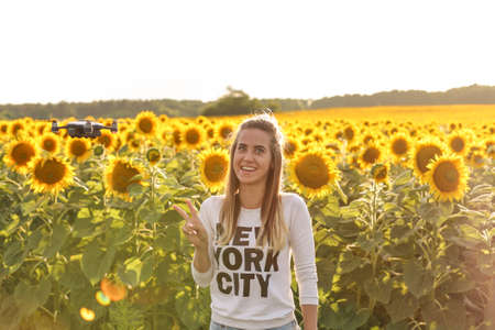Beautiful young woman having fun with a mini drone outdoors.の写真素材