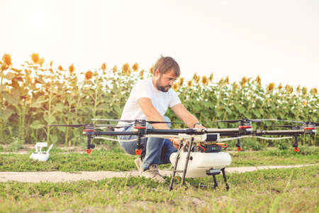 Preparing a drone for take off despite the sunset. Octocopter flights outdoors, aerial imagery and tech hobby, recreation concept.の写真素材