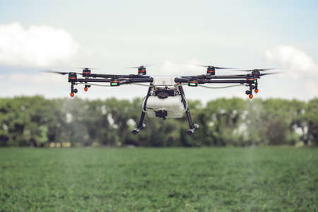 Drones spraying pesticides to grow potatoes. Industrial agriculture and smart farming concept.の写真素材