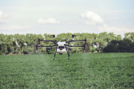 Drones spraying pesticides to grow potatoes. Industrial agriculture and smart farming concept.の写真素材