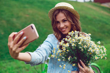 Beautiful young woman doing selfie on her phoneの写真素材