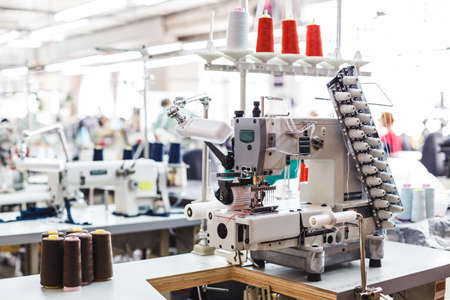 Professional sewing machine with different colors of threads in the textile factory.の写真素材