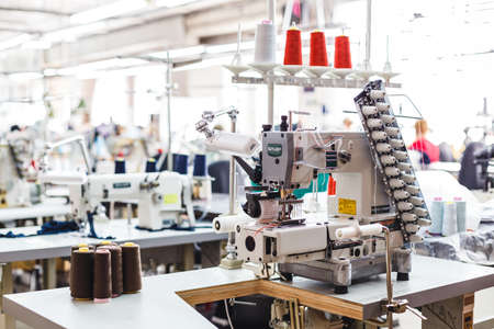 Professional sewing machine with different colors of threads in the textile factory.の写真素材