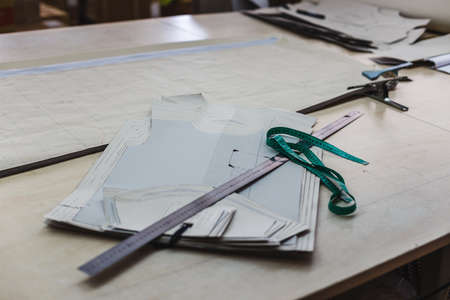 Still life photo of a clothes pattern template with ruler, tape measure on table. Sewing and tailoring tools and accesories.の写真素材