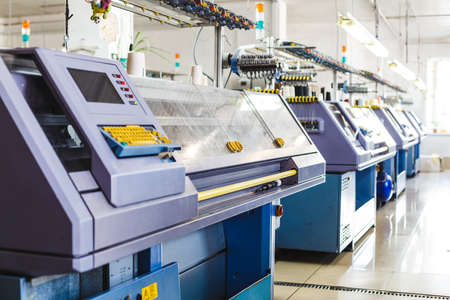 Textile industry with knitting machines in factory. Knitting and weaving machines in textile industryの写真素材