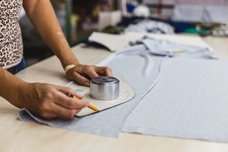 Closeup view if woman hands patterning and tailoring. Tailor woman working in his tailor shop,