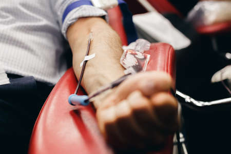 The donor blood donates blood in the clinic on a special chair. Blood sampling procedure for blood bankの写真素材