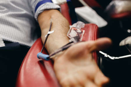 The donor blood donates blood in the clinic on a special chair. Blood sampling procedure for blood bankの写真素材