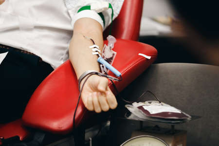 The donor blood donates blood in the clinic on a special chair. Blood sampling procedure for blood bankの写真素材
