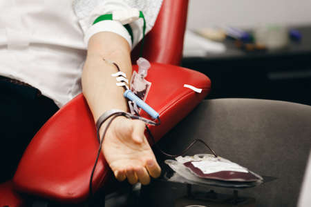 The donor blood donates blood in the clinic on a special chair. Blood sampling procedure for blood bankの写真素材