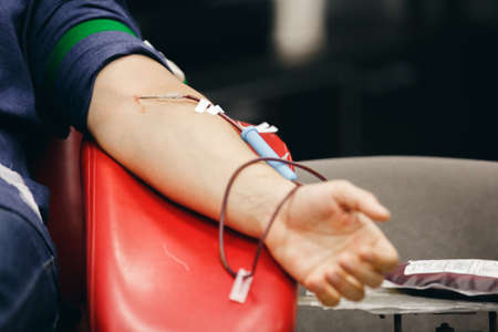 The donor blood donates blood in the clinic on a special chair. Blood sampling procedure for blood bankの写真素材