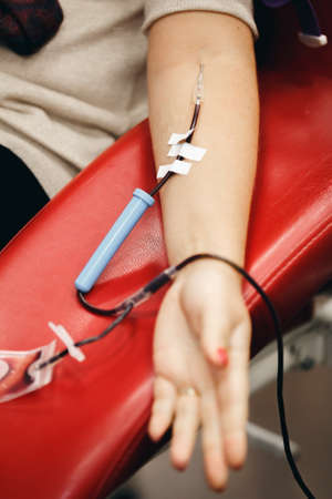 The donor blood donates blood in the clinic on a special chair. Blood sampling procedure for blood bankの写真素材