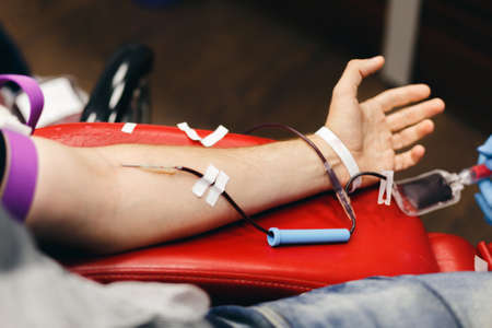 The donor blood donates blood in the clinic on a special chair. Blood sampling procedure for blood bankの写真素材