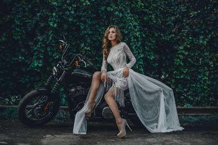 Young girl bride on a new mans motorcycle. Waiting for his princeの写真素材