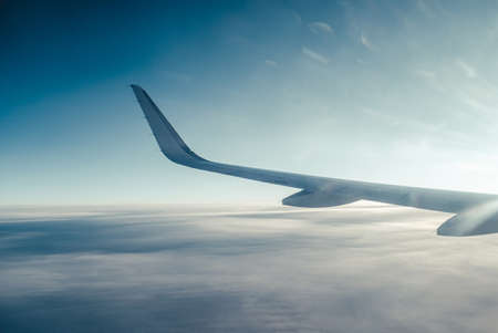 Airplain wing view thrue porthole in the skyの写真素材