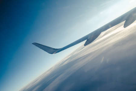 Airplain wing view thrue porthole in the skyの写真素材