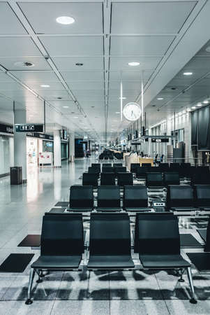 Modern Airport Departure Lounge with black chairs and white clockの写真素材