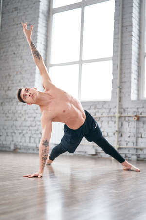 Handsome ballet dancer training in the gym. Warm up on the floor.の写真素材