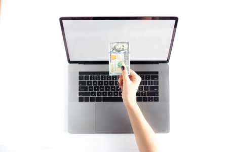 Lap top topview with hands taking money. Mockup developing tool.の写真素材