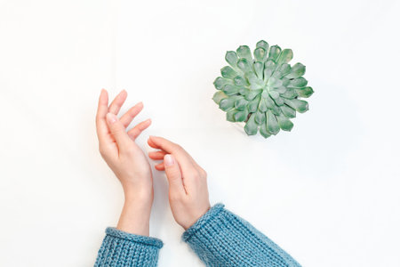 Closeup of hands of a young woman with manicure on nails against white background