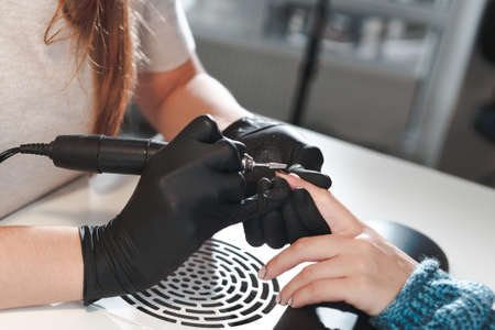 The process of removing nail polish with a milling cutter for a manicureの写真素材