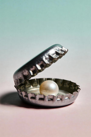 open metal bottle cap with pearl inside on minimal backgroundの素材