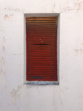 Red shutter on white wall