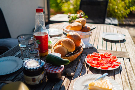 Basket of White Bread on Wooden Breakfast Table Outdoors in the Morning Sunの写真素材