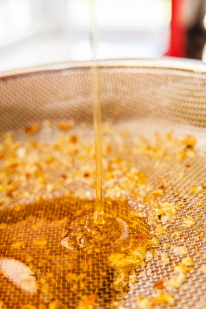 Bee Honey Trickles Down Into the Sieve Mesh Extreme Close Upの写真素材