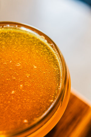 Delicious Bee Honey Nectar Filled to the Brim of a Honey Jar Extracted from Beekeeping Harvestの写真素材
