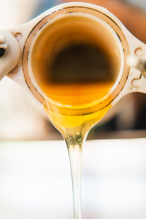 Freshly Extracted Sweet Bee Honey Flowing Out a Barrel Extreme Close Upの写真素材