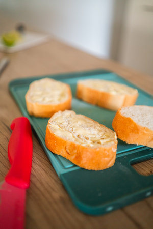 Slices of White Bread with Butter Spread on a Cutting Plateの写真素材