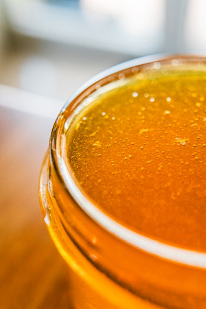 Honey Jar with Sweet Bee Honey Freshly Extracted and Harvested Filled to the Brim of the Glassの写真素材