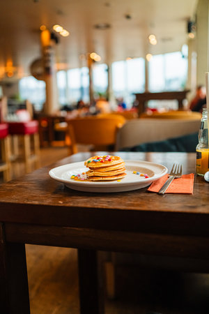 Delicious Stack of Pancakes Topped with Colorful Chocolate Lentiles and Sweet Honeyの写真素材