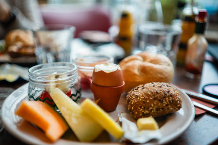 Open Boiled Egg in the Middle of a Breakfast Plate with Bread and Fruitsの写真素材