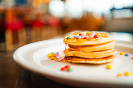 Small Stack of Pancakes with Dripping Honey and Chocolate Lentils on Topの写真素材