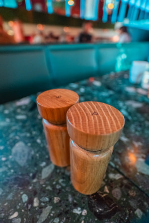 Wooden pepper and salt dispenser on a stone tableの写真素材