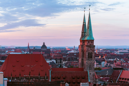 Red Morning Sunlight Indirectly Shining on the Buildings and Church Towers of the City of Nurmbergの写真素材