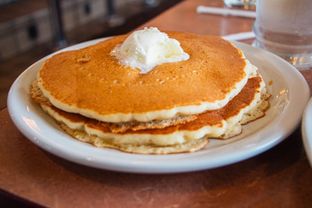 Soft Stack of Pancakes Topped With Butter on a White Plate Served in an American Dinerの写真素材