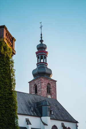 Traditional Church Tower Building with a Chapel Rising in the Blue Sky on a Sunsetの写真素材