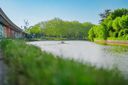 Rowing Team Rows a Skiff on a River in the Water Training for Competition During a Sunny Summer Dayの写真素材