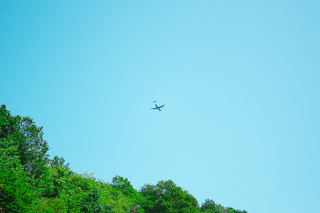 Military Transportation Aircraft Flying in the Sky Over a Natural Environmentの写真素材