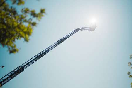 Fire Truck Extended Fire Ladder Operation on a Sunny Summer Dayの写真素材