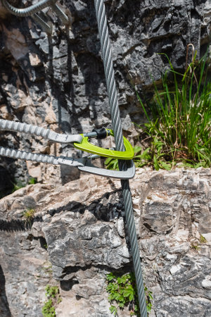 Two Carabiner With Safety Rope on a Steel Wire of a Stone Climbing Pathの写真素材