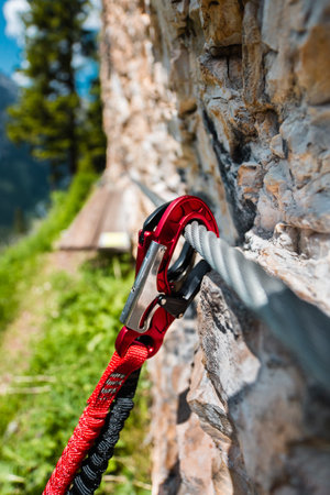 Carabiner Mounted on a Steel Wire Close to a Stone Climbing Wallの写真素材