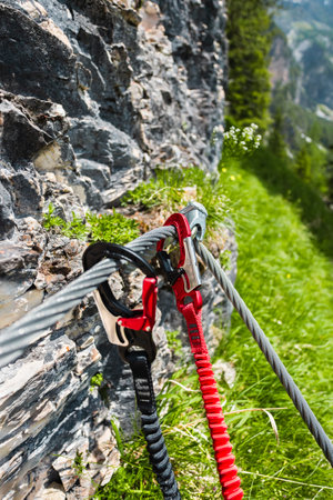 Double Carabiner Safely Mounted on a Steel Wire Cable Close to a Stone Climbing Wallの写真素材