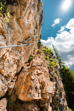 Mountain Cliff with a Steel Climbing Wire Cable Going Upの写真素材